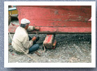 Man repairing fishing boat, Ancud
